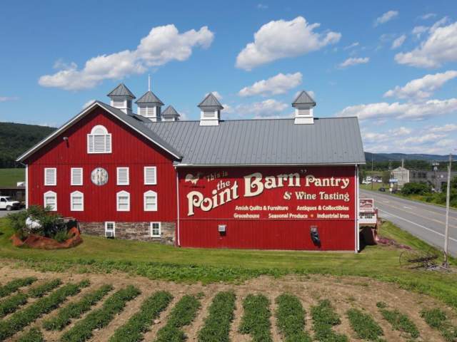 Picture of the outside of the point barn with a pretty blue sky in the background.