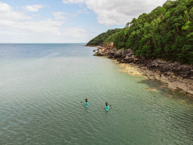 A drone shot of two people kayaking in Oxwich