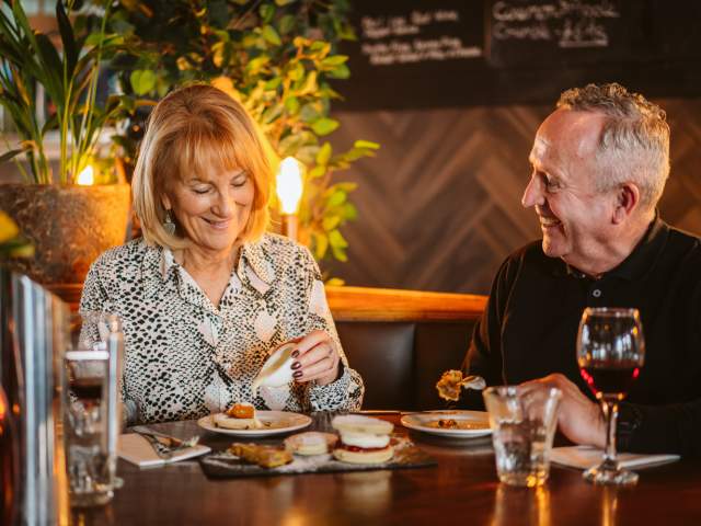 An older couple eating food in a restaurant
