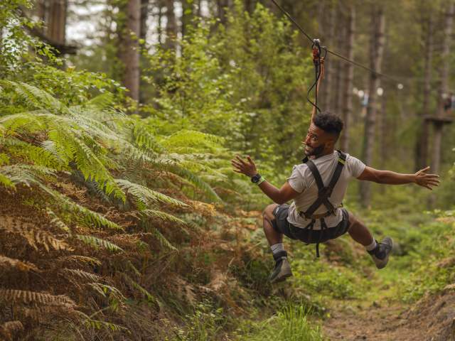 Man riding a zipline at go ape
