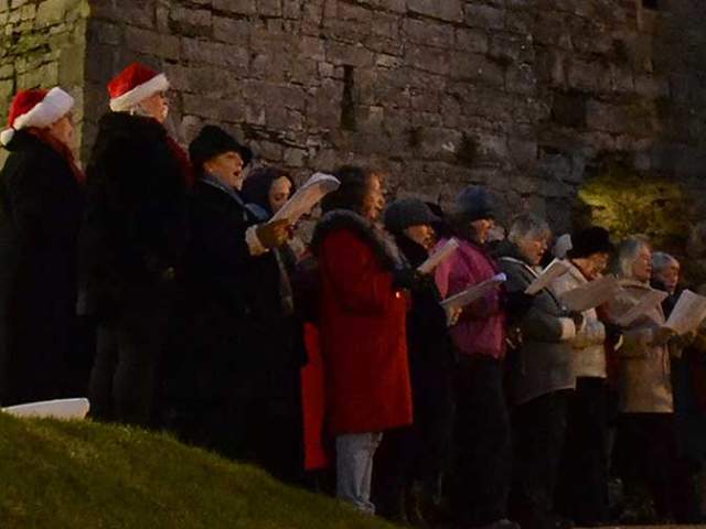Carol singers in front of Oystermouth Castle