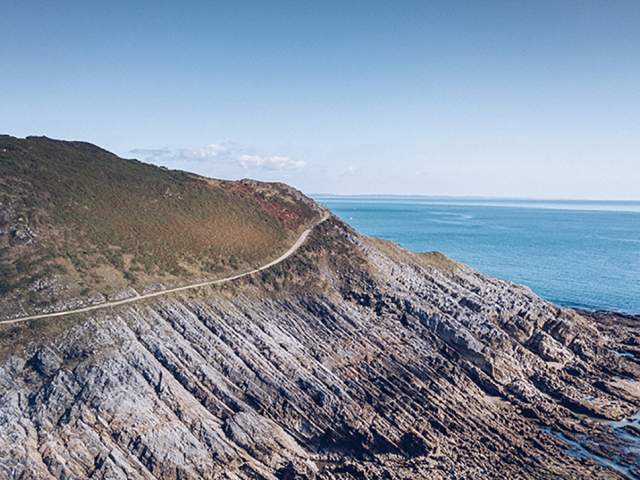 Landscape shot of a path along a ragged coastal edge.