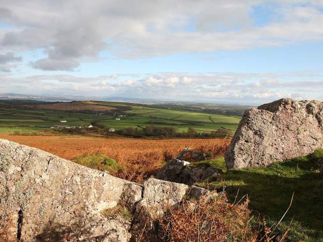 Rural Gower landscape with a rock formation in the foreground.