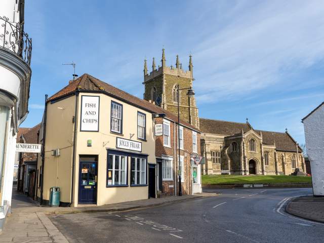 A church and fish and chip shop street under blue skies
