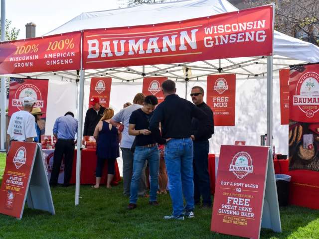 Visitors trying samples of Baumann Wisconsin Ginseng at their booth.