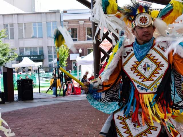 A member from the HoChunk dance group performing on stage at the 400 block.