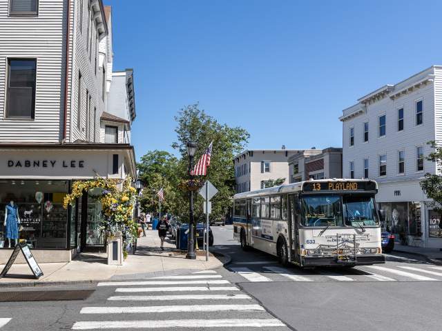 A Bee-Line Bus pass through the town of Rye where the streets are lined with shops and restaurants.