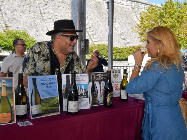 A woman drinks from a glass of wine.