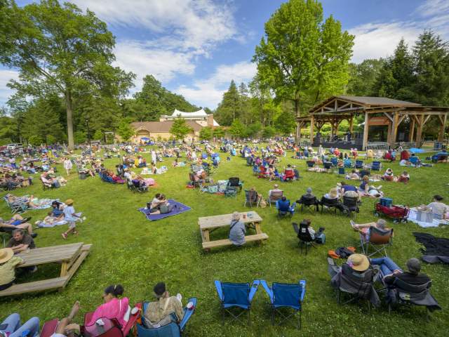 A photo of people sitting on the lawn of Friends Field on a sunny day.