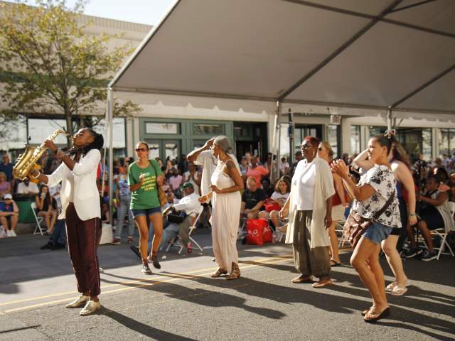 A jazz saxophonist is playing outdoors.
