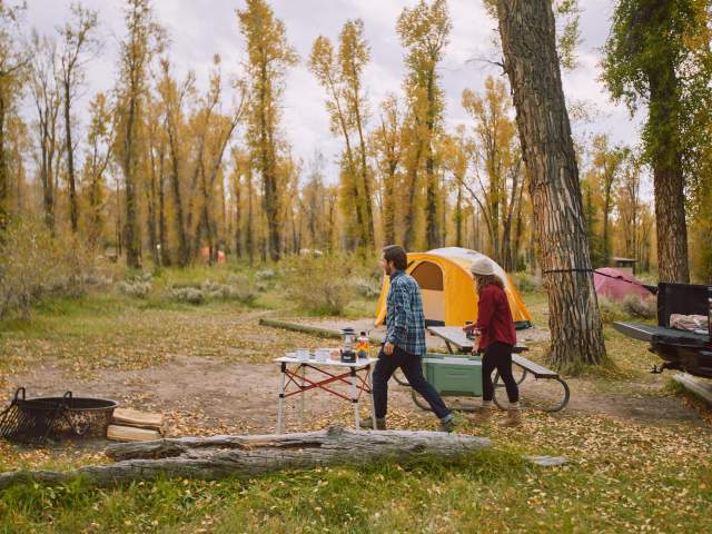 A young couple unloading their truck, setting up their tent camp site in Teton County