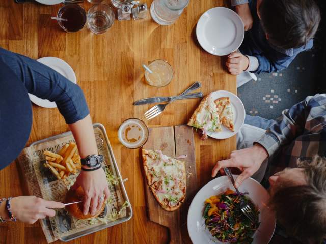 Family eating pizza, burgers and a salad at the Mangy Moose in Jackson, Wyoming.