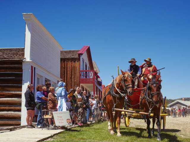 South Pass City crowd watching a carriage and horse ride past.