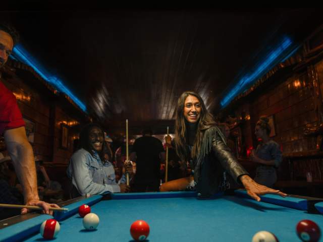 Group of people playing pool at the Mint Bar.