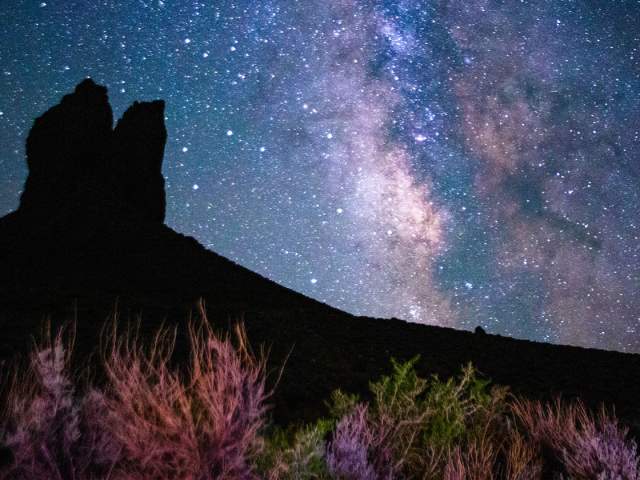 Boars Tusk rock formation silhouetted against a starry night sky in Sweetwater County, Wyoming.