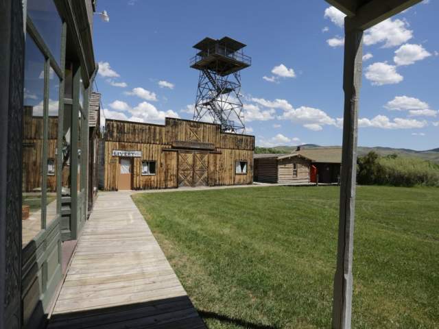 A log building amongst lush greenery in Grand Encampment Copper District, a ghost town in Wyoming. 