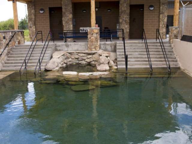 A natural hot spring pool in front of a building at the entrance of Hobo Pool.