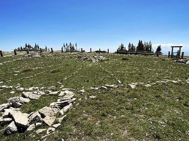 greenery and rocks in front of a clear sky at Bighorn Medicine Wheel, a stop in Lovell