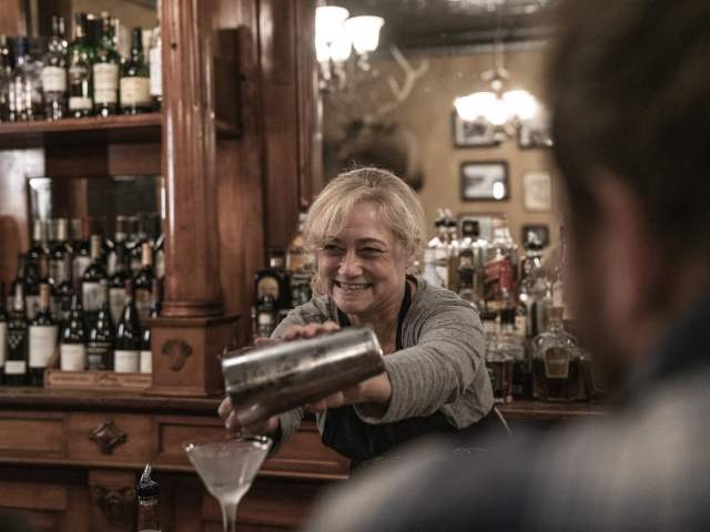 Woman serving a martini at the bar.