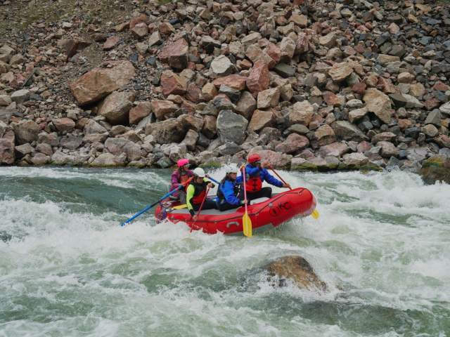Group white water rafting down a river.