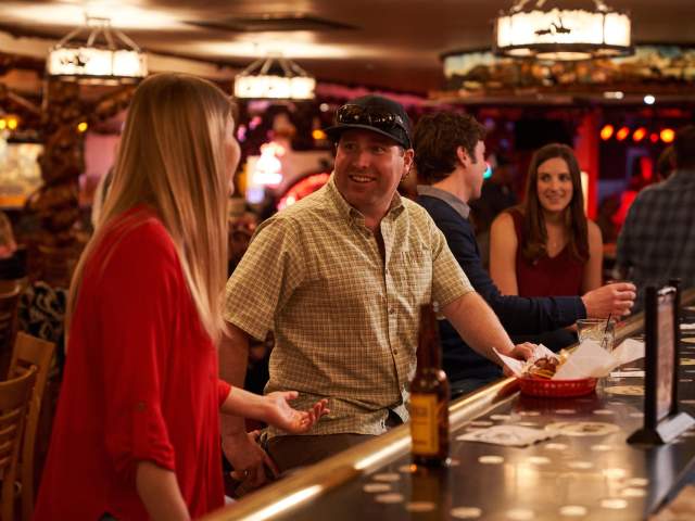 Couples talking and drinking at the bar.