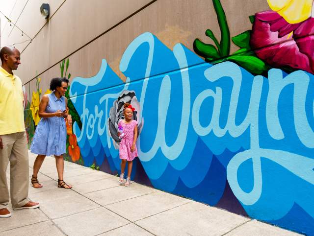 Family by a mural in downtown Fort Wayne