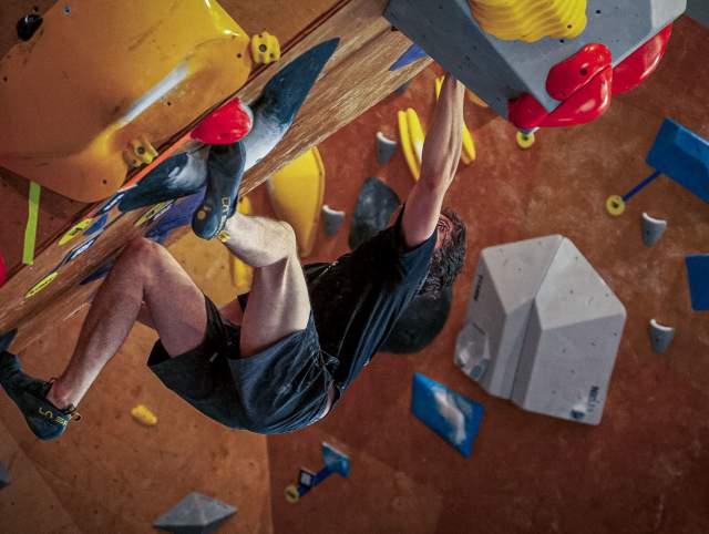 Man climbing a diagonal overhanging wall at Summit City Climbing Co. in Fort Wayne, Indiana.
