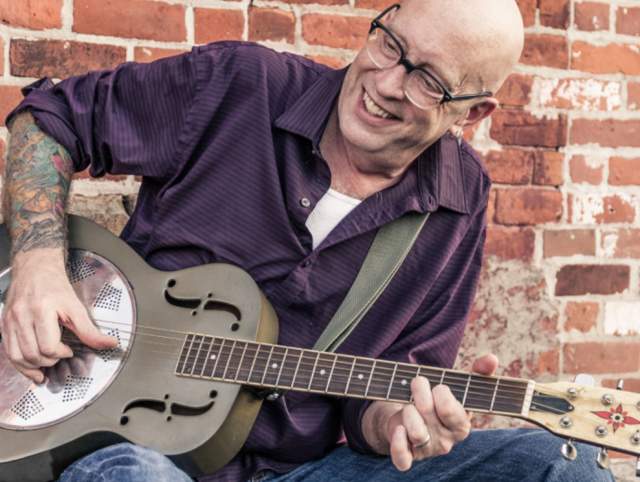 Image of Andy Pauquette playing his guitar
