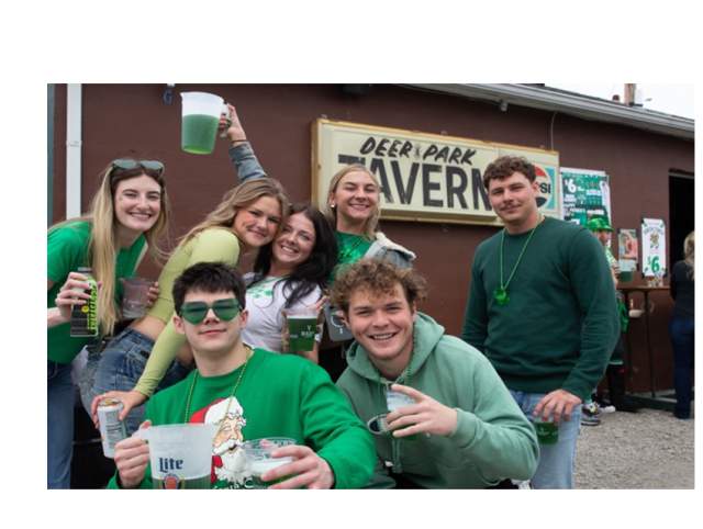 Patrons pose in front of Deer Park Irish Pub during St. Patrick's Day celebration.