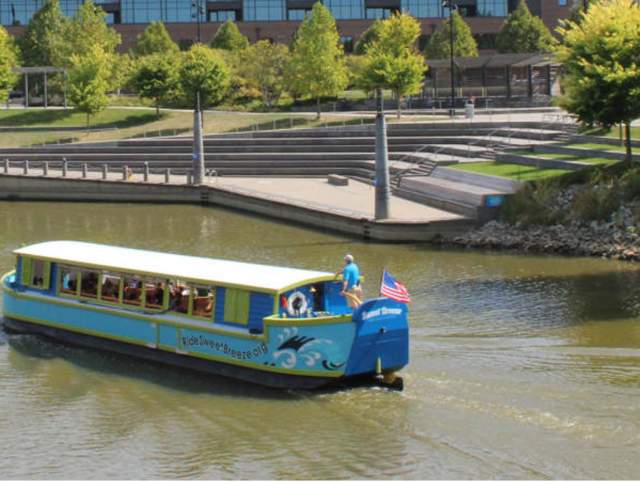 The Sweet Breeze Canal Boat replica cruises on the Saint Mary’s River near Promenade Park in Fort Wayne, IN