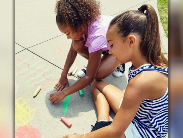 Girls drawing with chalk at Science Central in Fort Wayne. World Art Day is April 18, 2026.