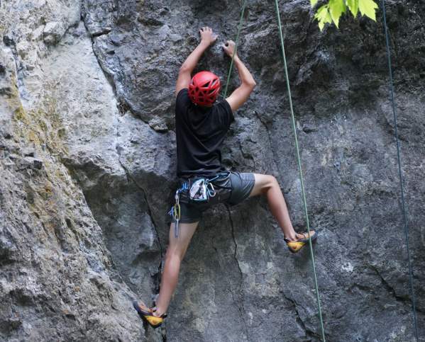 young man rock climbing outdoors