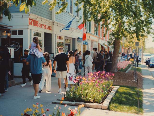 Crowd walking on sidewalk in front of heritage shops