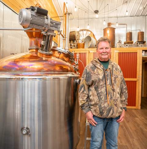 Tall Pines Distillery owner Keith poses for a photo in his Distillery room.