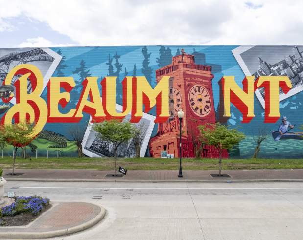 a mural spelling out Beaumont with iconic images like the river, the clock tower, alligators, oil derricks, bridge, and downtown skyline