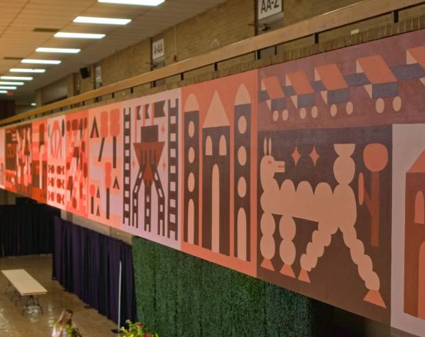a mural showing patterns of common Texas themes like animals, architecture, food, and culture