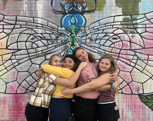 Teens posing in front of Dragonfly wall mural in Beaumont