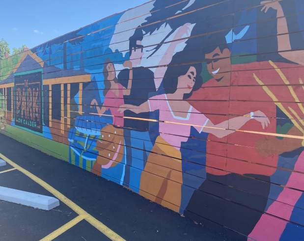 a mural showing people dancing outside a restaurant patio area