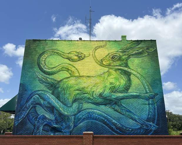 a mural showing a rabbit chasing a snake