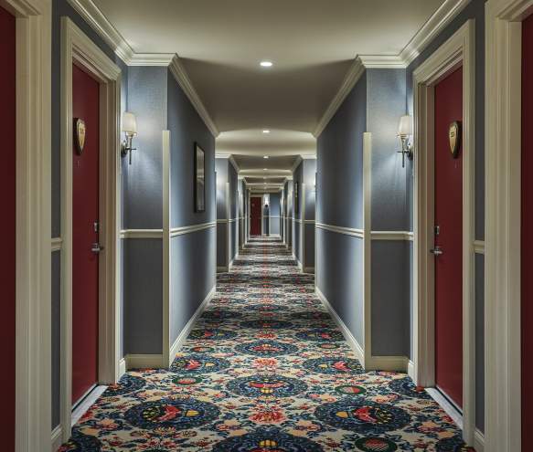 A hallway lined with guest room doors at the Graduate Hotel