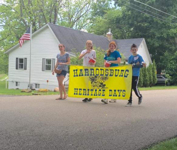 Four kids holding the Heritage Days sign ahead of the festival's parade