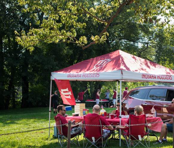 People tailgating under a canopy