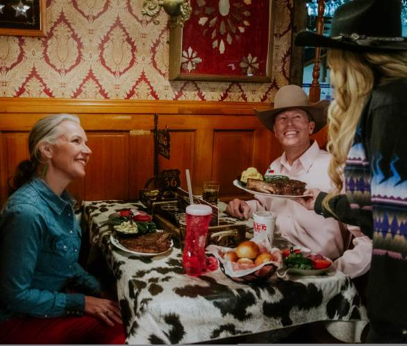 Couple getting served steaks by a waitress at The Big Texan