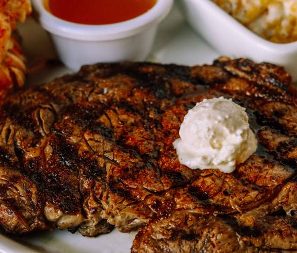 picture of steak with butter on top from x- steakhouse