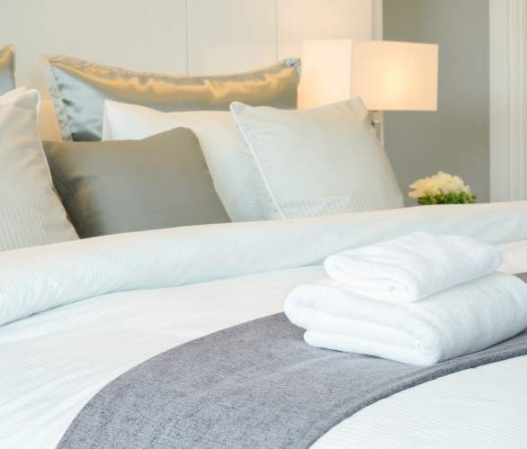 photo of bed with white sheets, and pillows in a cozy, clean room