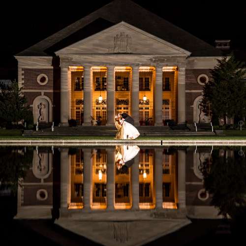 Newly weds pose outside the hall of springs at night