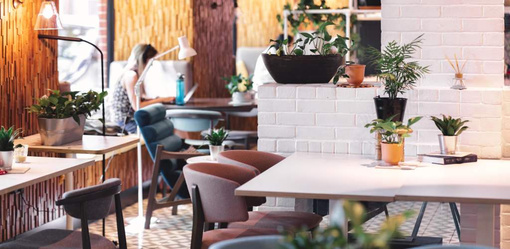 Inside of room2 cafe Southampton with tables and chairs. Someone is working in the background