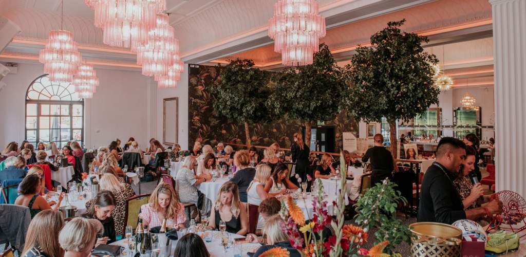 Groups of women dining at large round tables at The Grand