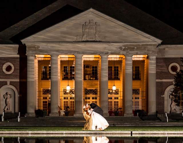 groom kissing his bride outside the hall of springs at night