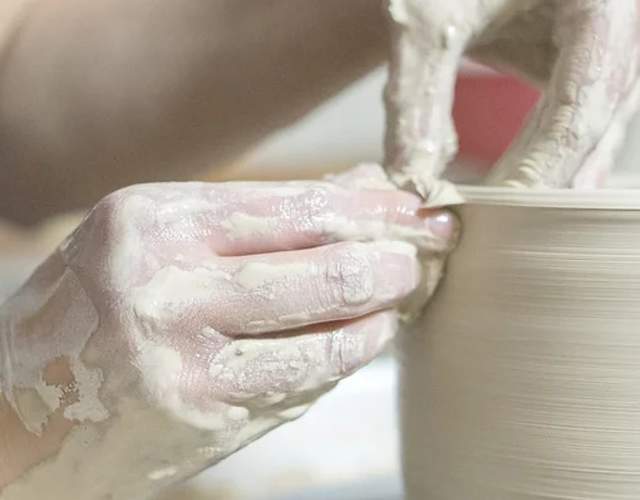 Close up of hands making pottery